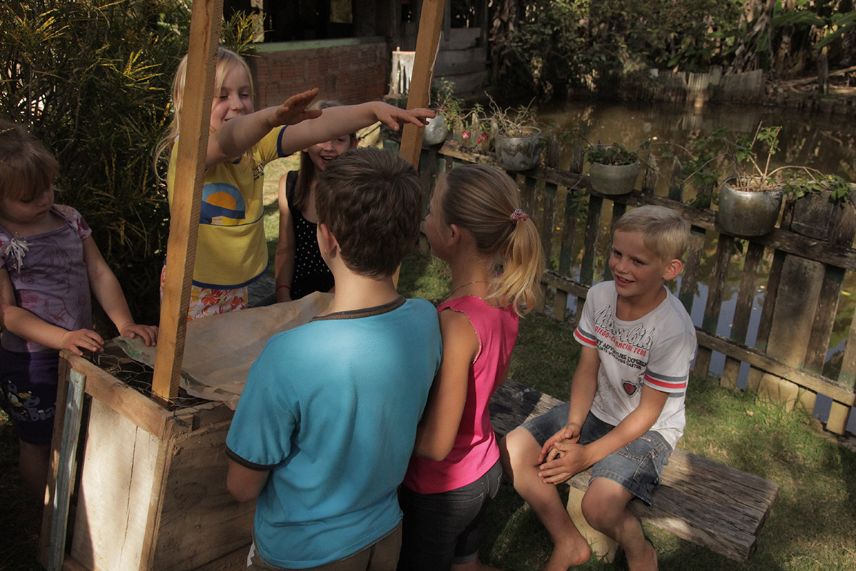 Foto de crianças brincando em volta de uma barraca.
