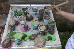 Foto de um fogão quebrado cheio de copos e pratos com lama.