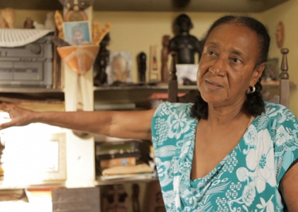 Foto de uma mulher, seu braço direito esta estendido ao ar.