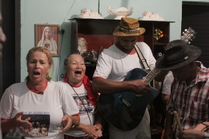 Foto de duas mulheres cantando e dois homens tocando instrumentos.
