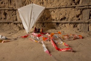 Foto de uma pipa encostada em uma parede.