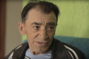 Foto de um senhor sorrindo enquanto fala.