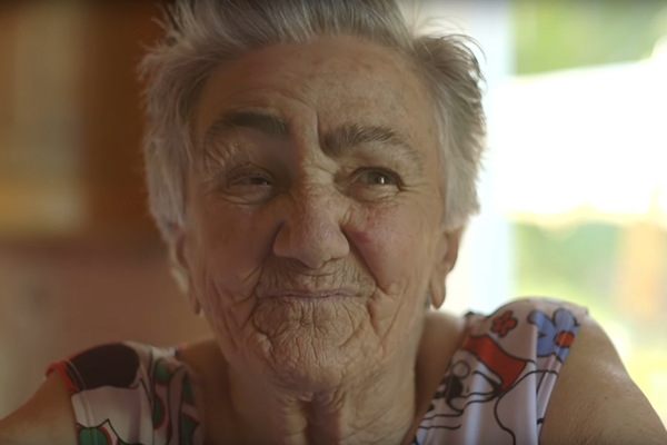 Foto de uma senhora sorrindo para a câmera.