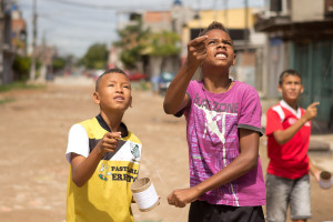 Foto com Três garotos soltando pipa.
