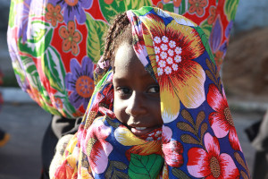 Imagem de uma garota envolvida por um lenço todo florido