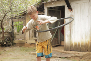 Foto de um garoto brincando com um bambolê.