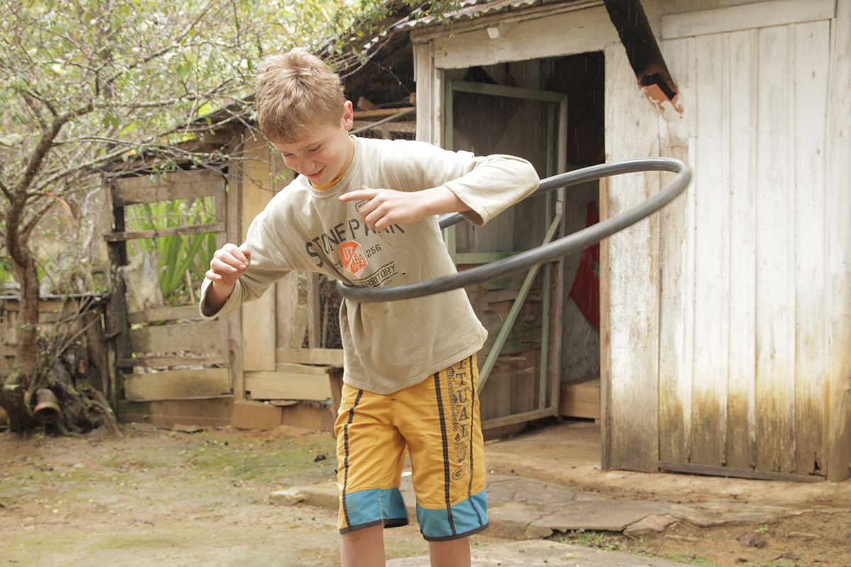 Foto de um garoto brincando com um bambolê.