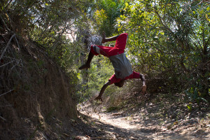 Foto de um garoto dando um salto mortal.