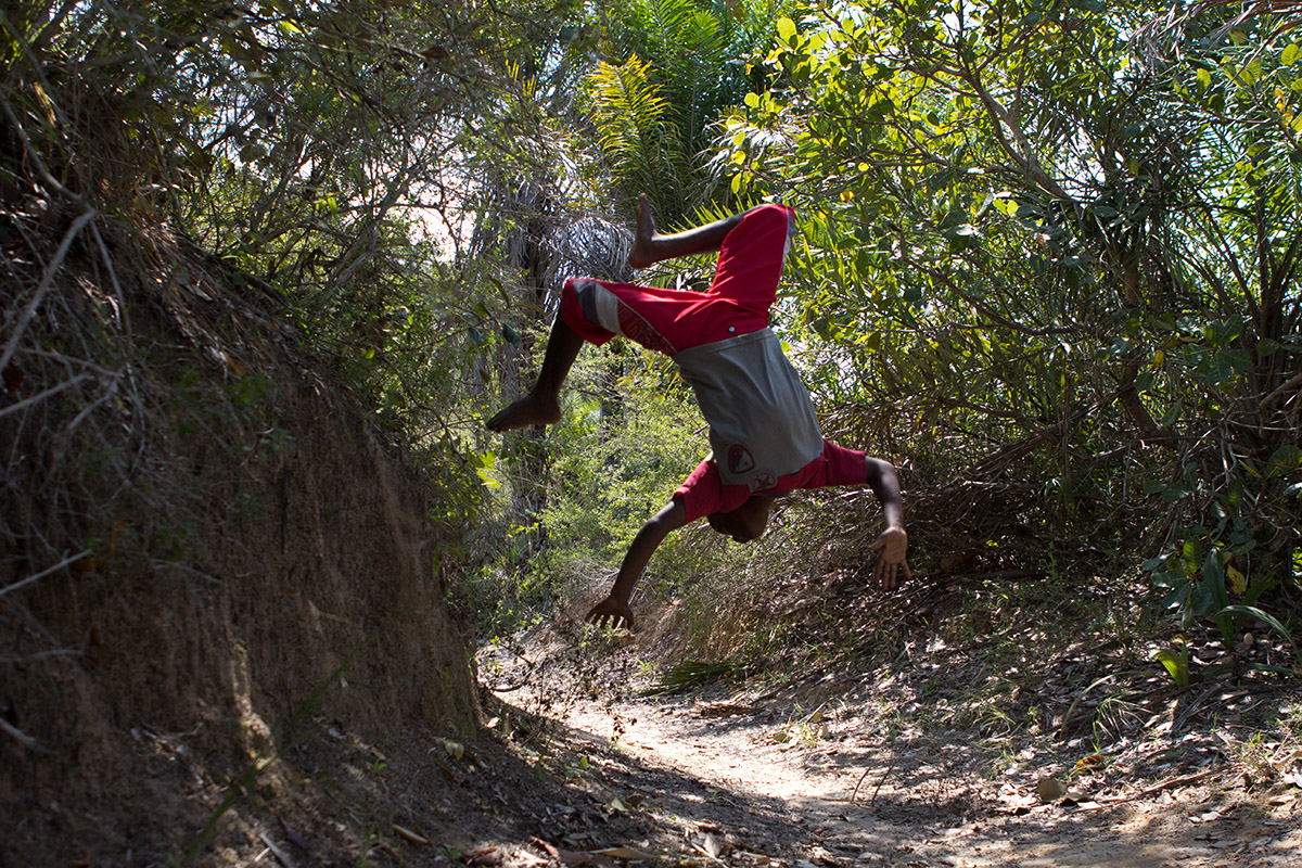 Foto de um garoto dando um salto mortal.