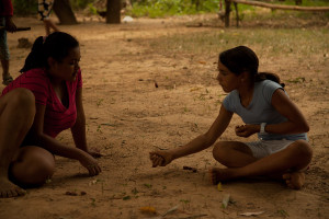 Foto de uma interação entre duas garotas sentadas no chão