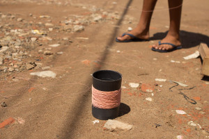 Foto de um carretel de linha de pipa e os pés de uma criança.
