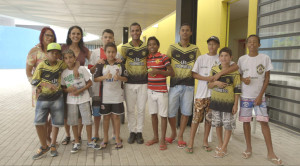 Foto ilustra várias pessoas, onze garotos e duas mulheres.