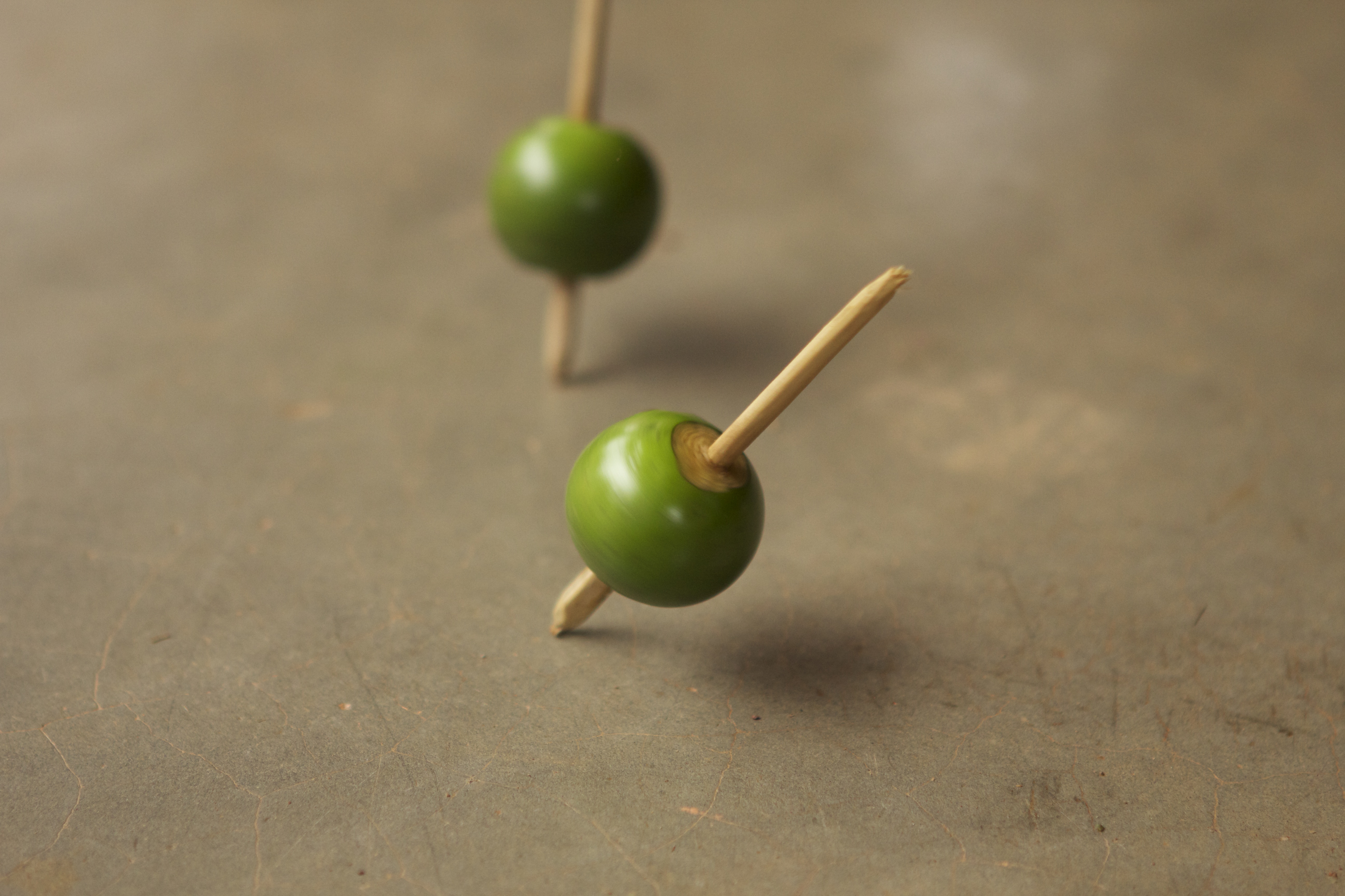 Foto de dois peões feito a mão giram em um chão