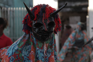 Foto de um bumba meu boi com uma máscara de monstro.