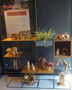 Foto de uma estante com vários brinquedos indígenas.