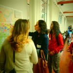 Foto com três mulheres uma esta apontando para um mapa, as outras duas estão observando este mapa.