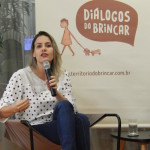 Foto ilustrando uma mulher falando ao microfone.