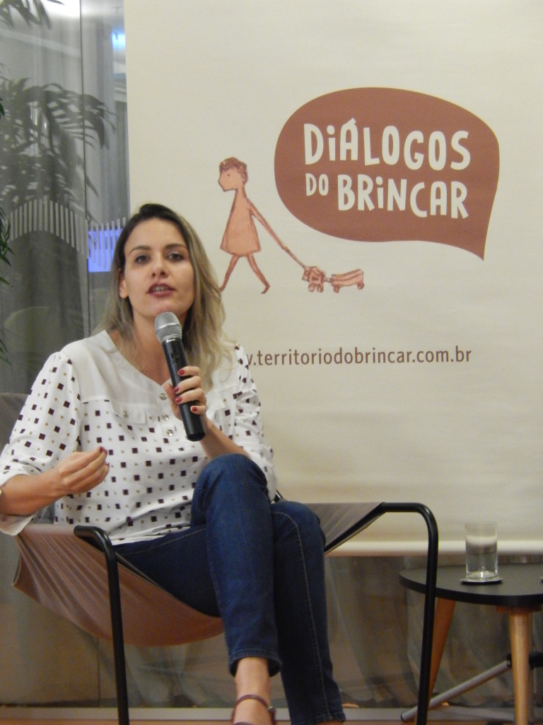 Foto ilustrando uma mulher falando ao microfone.