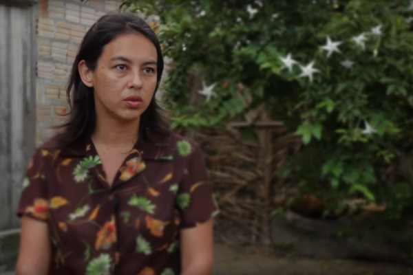 Foto de uma mulher que veste marrom olhando para frente.