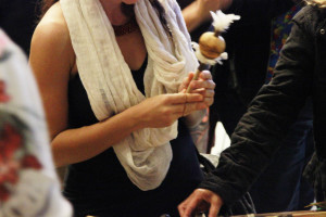 Foto ilustrando uma mulher com um objeto indígena nas mãos.