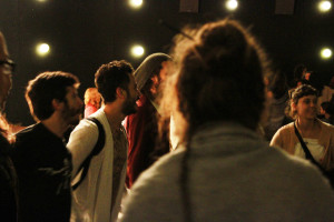 Foto de um grupo de pessoas de mãos dadas em que todos estão felizes prestigiando o evento.