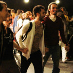 Foto de um grupo de pessoas de mãos dadas em que todos estão felizes em um evento.