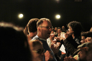Foto de inúmeras pessoas de mãos dadas em um evento.