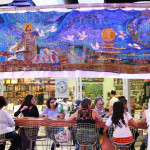 Imagem de um grupo de mulheres sentadas em volta de uma mesa.