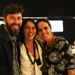 Imagem de duas mulheres e um homem sorrindo para a câmera.