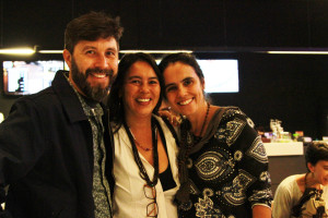 Imagem de duas mulheres e um homem sorrindo para a câmera.