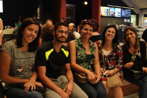 Foto com cinco pessoas, quatro mulheres e um homem sorrindo para a câmera .