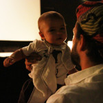 Foto de um homem erguendo um bebê.