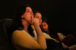 Foto ilustrando á reação de duas mulheres assistindo uma palestra , onde a segunda mulher ao centro da foto tem uma menina dormindo ao seu colo.