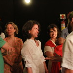 Foto ilustrando interação entre pessoas , composta de três mulheres ao centro e um homem á esquerda e um homem á direita.