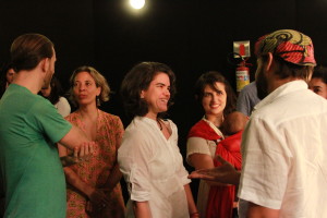 Foto ilustrando interação entre pessoas , composta de três mulheres ao centro e um homem á esquerda e um homem á direita.