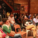 Foto onde há várias pessoas sentadas prestando atenção á uma palestra