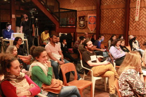 Foto onde há várias pessoas sentadas prestando atenção á uma palestra