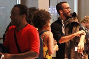 Foto ilustrando interação entre pessoas , á esquerda á um homem negro , ao centro uma mulher negra e á direita um outro homem.