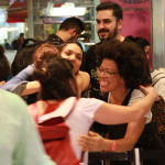 Foto ilustrando interação entre pessoas , em um local onde ao centro da foto vemos quatro mulheres trocarem abraços.