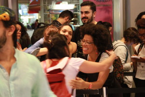 Foto ilustrando interação entre pessoas , em um local onde ao centro da foto vemos quatro mulheres trocarem abraços.