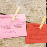 Foto ilustrando dois bilhetes presos em um varal , por prendedores que está fixado em um pilar .