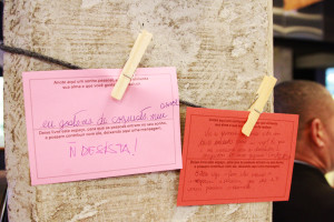 Foto ilustrando dois bilhetes presos em um varal , por prendedores que está fixado em um pilar .