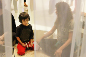 Foto ilustrando diálogo entre uma criança e uma mulher , onde a criança está usando um fone de ouvido.