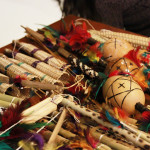 Foto de uma mesa com inúmeros artefatos indígenas mais próximos.