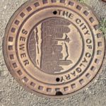 Imagem de uma tampa de um bueiro, nele há uma estampa da cidade de Calgary.