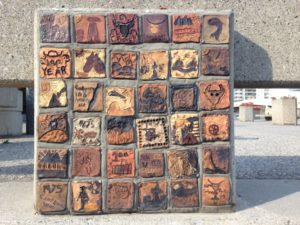 Uma placa de pedra com várias ilustrações a gravadas a ela.