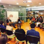 Fotografia de uma reunião, cadeiras posicionadas em círculo. As pessoas conversam.